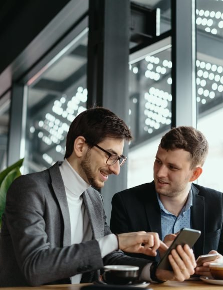 two businessmen having a conversation using a smartphone